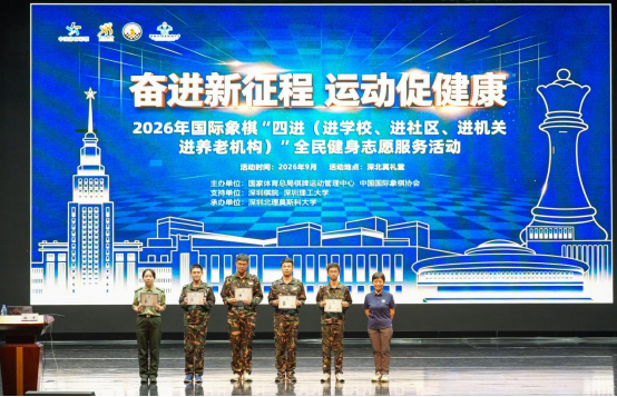 谢军与学生在2026年国际象棋“四进”志愿服务活动背景板前合影。