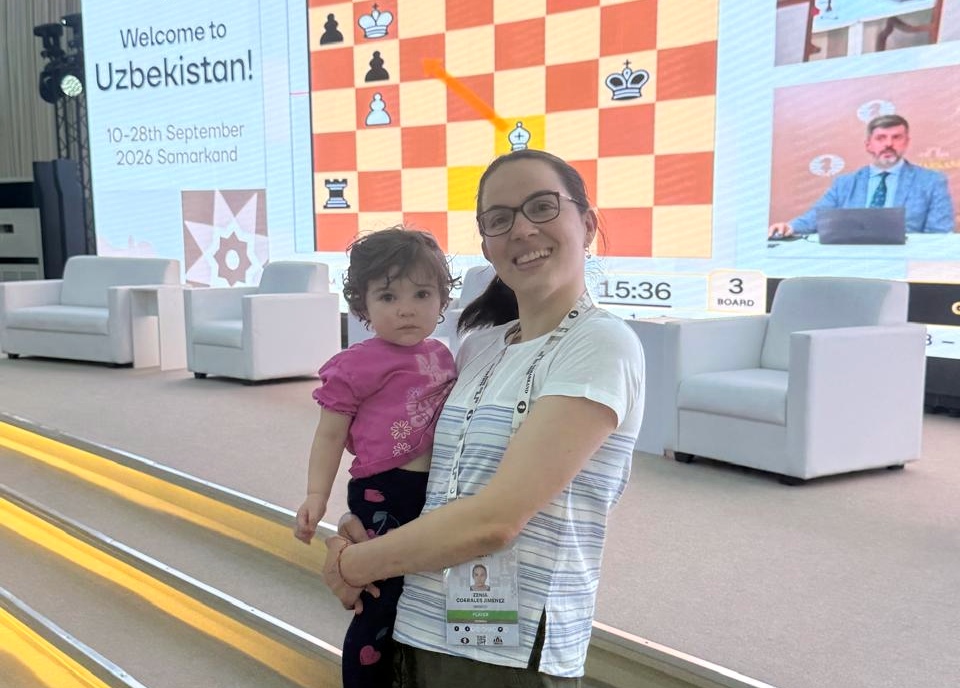 一位棋手在奥赛场地抱着孩子。