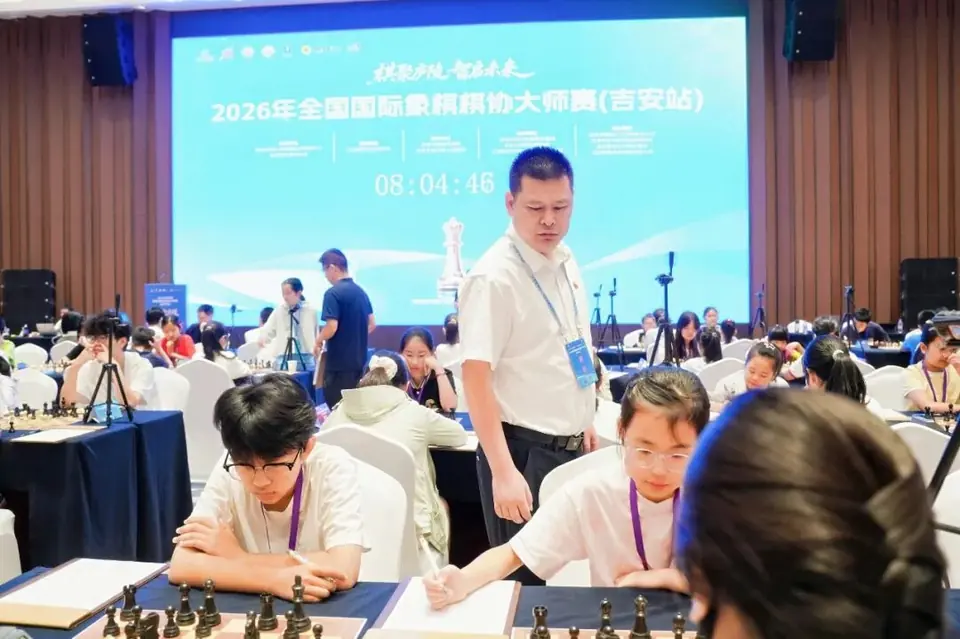 吉安棋协大师赛比赛大厅，棋手在棋盘前对弈。