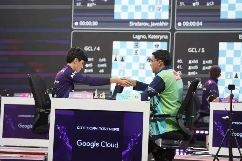 辛达罗夫与阿南德在全球国际象棋联赛赛场握手。